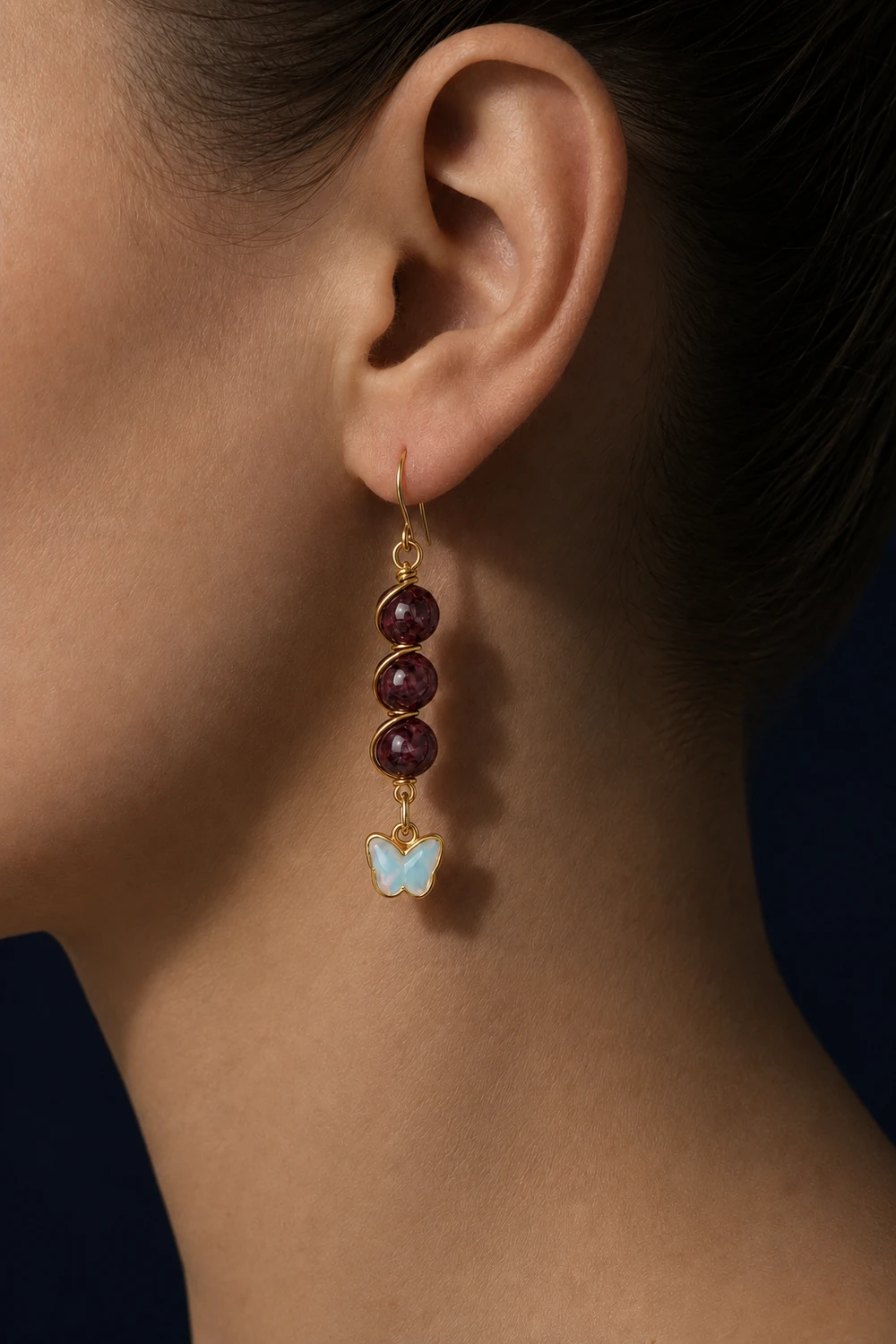 Lal (Garnet) 8mm Üçlü Sıralı Burgu Kelebek Uçlu Küpe takılı hali yakın çekim gece
